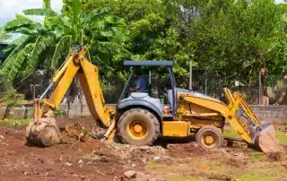 Heavy machinery actively clearing overgrown land, showcasing brush removal and prepared ground for property development.