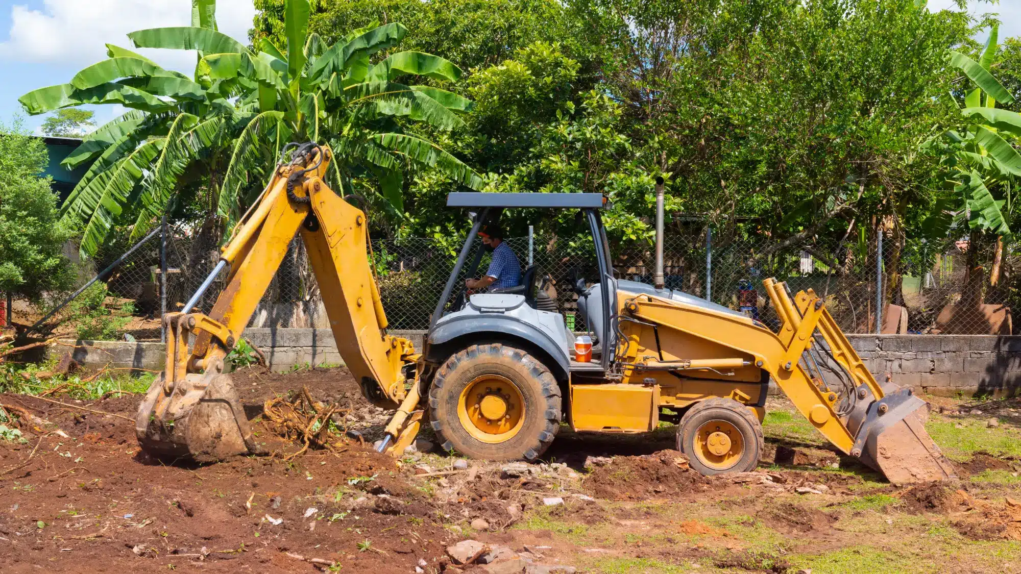 Heavy machinery actively clearing overgrown land, showcasing brush removal and prepared ground for property development.