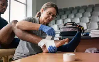 Doctor examining athlete's injured knee during consultation