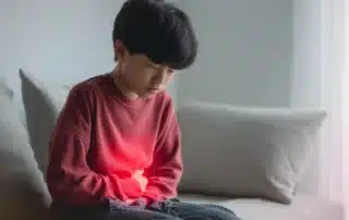 Child experiencing abdominal pain at home, highlighting symptoms that may require evaluation by a pediatric gastro surgeon in Gainesville, GA.