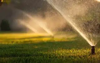 Lawn sprinkler system watering green grass, highlighting the benefits of choosing a professional irrigation contractor in Waterford, CT for reliable lawn care.