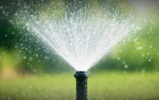 A professional sprinkler installation team in Glastonbury, CT setting up garden irrigation.