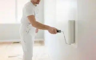House showcasing professional interior and exterior painting services with vibrant color drops.